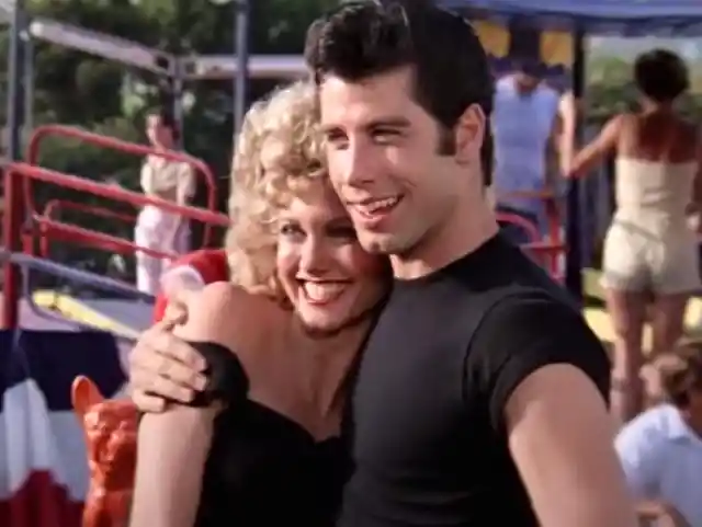 What does the word "Grease" got, according to the lighting-packed film's opening song? 